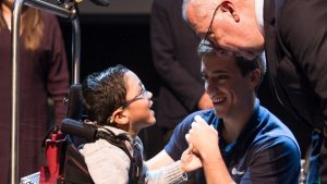 Un pequeño niño celebra junto con su terapeuta como parte de la donación a niños con parálisis cerebral realizado por La Iglesia de Jesucristo de los Santos de los Últimos Días.