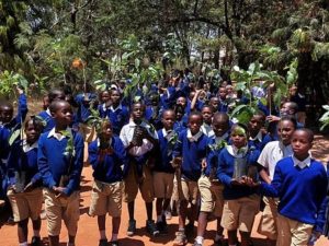 Niños llevan los árboles frutales en Tanzania donados por la Iglesia. Créditos: La Iglesia de Jesucristo de los Santos de los Últimos Días