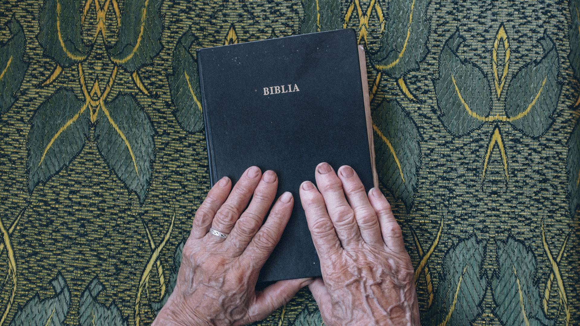 manos ancianas sostienen una Biblia